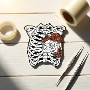 Gothic skull rib cage enamel pin with floral details on white wooden surface