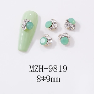 Detail view of light green cat eye stone butterfly nail charm with silver metal base