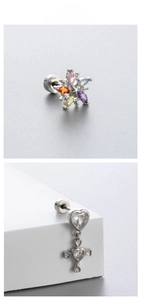 Detail of colorful star-shaped zircon ear stud and heart cross pendant with screw backs