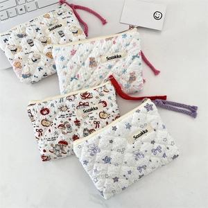 Close-up of quilted floral cotton pouches featuring cute animal prints and zipper details