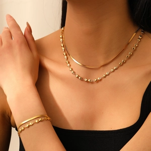 Détail d'un ensemble collier double rang en or 18 carats avec maille serpent et cœur