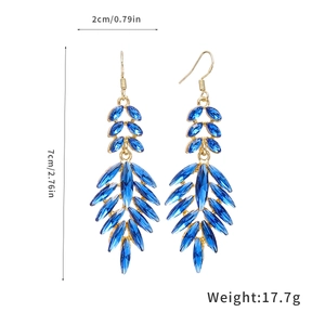 Detailed view of long gold leaf tassel earrings with blue crystals and size marking