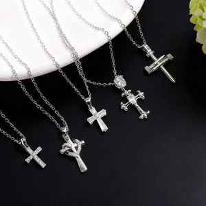 Five assorted silver stainless steel cross necklaces with zircon inlays on a bicolor base