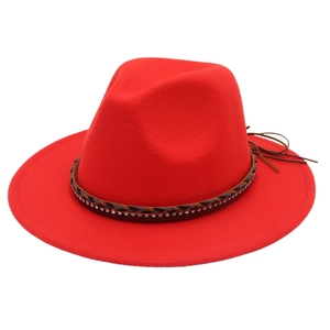 Dettaglio del cappello di lana rosso con fascia intrecciata e nappe in pelle