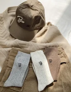 Détail de chaussettes en coton torsadé avec broderie SAM en gris, crème et marron