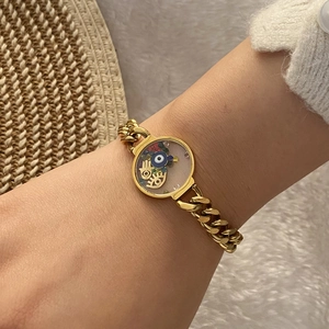 Gold chunky chain bracelet with Fatima hand and evil eye pendant worn on wrist