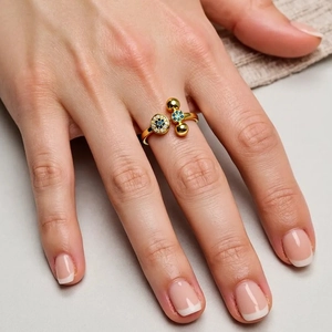 Detailed close-up of 18K gold-plated open ring with micro-set blue and white gemstones