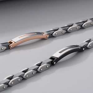 Detail of industrial style stainless steel bracelets with screw motifs and dual-tone finish