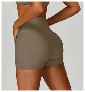 Detail view of high waisted ribbed yoga shorts showing body contouring and texture