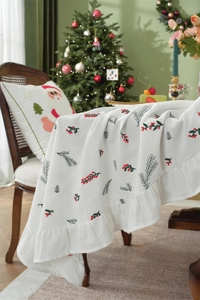 Close-up of cotton Christmas tablecloth featuring festive berry prints and ruffled hem edges