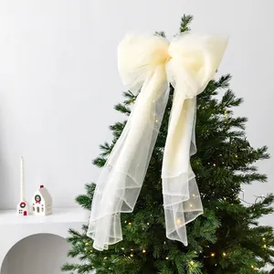 Elegant cream sheer mesh Christmas tree topper bow with long tassels and warm festive lights