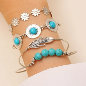 Detail view of Bohemian silver bracelet set with turquoise beads and feather cuff on wrist