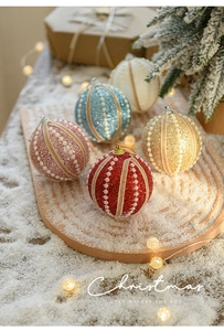 Detail of 8cm glitter Christmas balls with pearl accents on a rustic wood tray