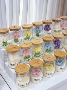 Macro view of various tulip and rose scented candles in glass jars with wooden lids