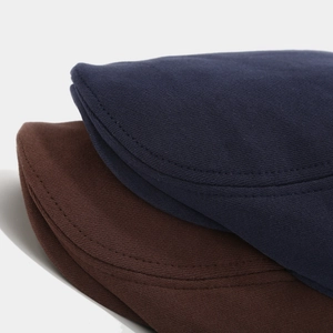 Gros plan détaillé de casquettes gavroche en coton tricoté en bleu marine et marron