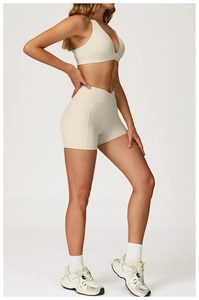 Detail view of beige yoga shorts featuring high waist cross-waistband and side pockets