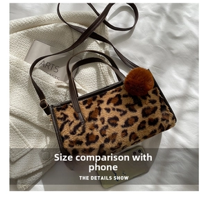 Leopard print plush handbag details with leather straps and pompom charm for size reference