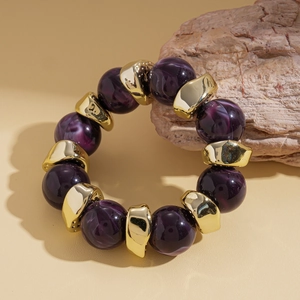 Dettaglio del bracciale vintage in acrilico con perle viola e inserti dorati