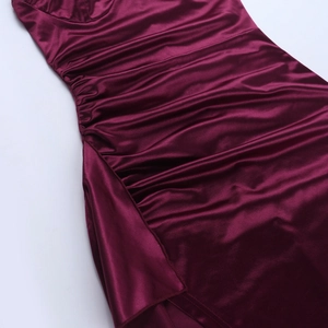 Vue macro de la robe en dentelle bordeaux montrant la fente latérale et les fronces