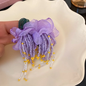Boucles d'oreilles fleurs en organza violet avec pompons perlés pour un look de vacances