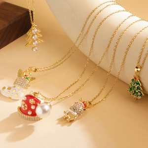 Close-up of gold Christmas necklaces with tree, sock, and reindeer charms on ceramic