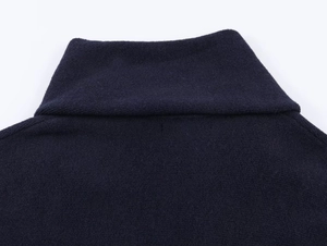 Close-up of the dark blue knitted collar and soft fabric texture on a short coat