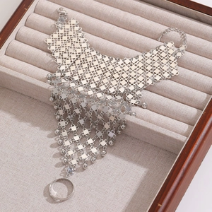 Detail of silver mesh hand chain bracelet with dangling beads and finger ring in jewelry box