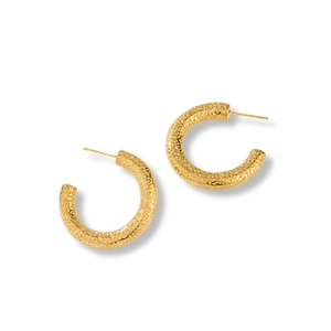 Close-up of golden C-shaped hoop earrings with hammered texture on white background