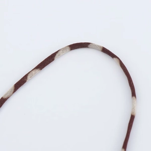 Macro view of woven brown and beige striped spaghetti strap for chiffon dress