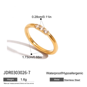 Vista detallada de un anillo de acero dorado con circonitas blancas y medidas