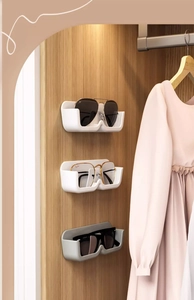 Detail of wall-mounted glasses organizers showing U-shaped slot design for storage