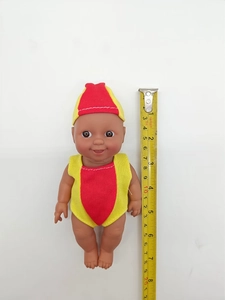 Vertical view of 18-20cm black baby doll with yellow measuring tape on white background