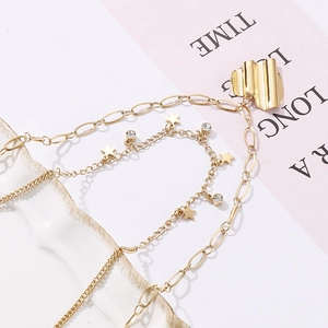 Détail de la chevillère dorée à plusieurs rangs avec étoile et cristal sur un magazine