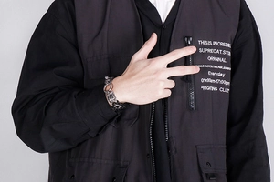Close-up of a punk style stainless steel braided leather bracelet worn by a male model