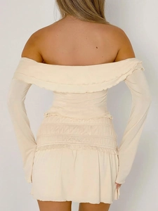 Detail view of beige off-shoulder long sleeve top with ruffled neckline and smocked waist