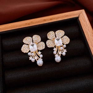 Detail of floral earrings with sparkling zircons and pearl fringe in a jewelry box