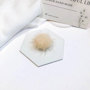 Close-up of soft fluffy beige mink fur ball accessory for DIY jewelry and hair accessories