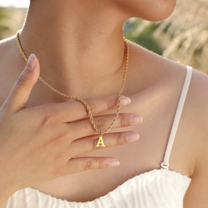 Close-up of gold stainless steel capital letter A pendant necklace on a rope chain
