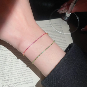 Close-up of pink and green tennis bracelets with crystals on a female wrist