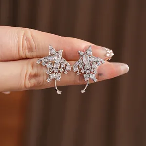 Star-shaped silver earrings with sparkling zircon stones and hanging meteor details