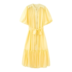 Detail of yellow chiffon midi dress featuring button-down front and waist tie drawstring