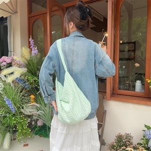 Détail du sac cabas vert clair à carreaux gaufrés avec texture plissée sur modèle