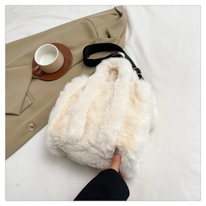 Detail of plush off-white faux fur tote bag with a removable black woven shoulder strap