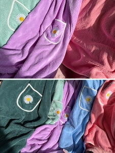 Detail showing waffle weave microfiber texture and daisy embroidery on a soft bath towel