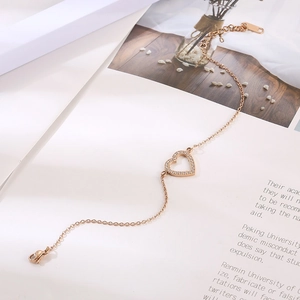 Détail du bracelet cœur en or rose avec micro-cristaux et chaîne à maillons réglable