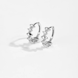 Detail of 925 sterling silver huggie earrings with conical studs and sparkling round zircons