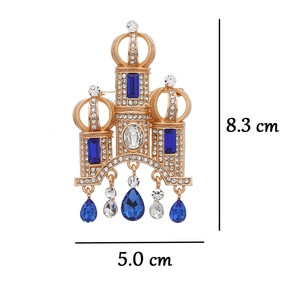 Detailed view of a vintage castle brooch with blue rhinestones and tassel charms