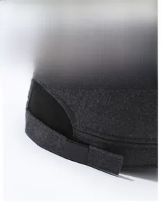 Detail of adjustable metal buckle and dark grey textured fabric on a men's winter flat cap