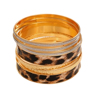 Detail van de boheemse stapelbare armbandset met luipaardprint en metalen ringen