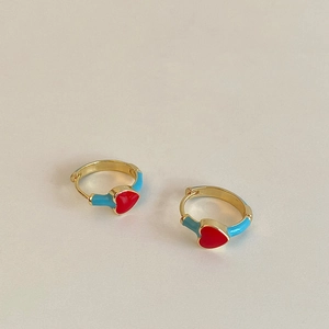 Detailed close-up of gold-plated heart earrings with red and light blue enamel coating